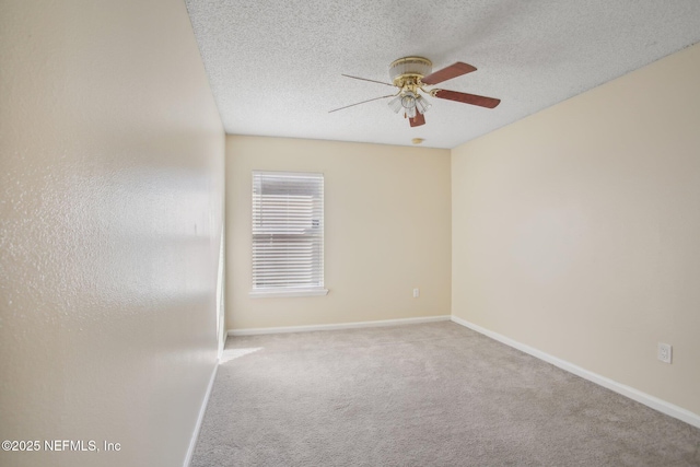 carpeted spare room featuring ceiling fan and a textured ceiling