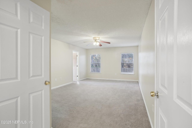 carpeted spare room featuring ceiling fan and a textured ceiling