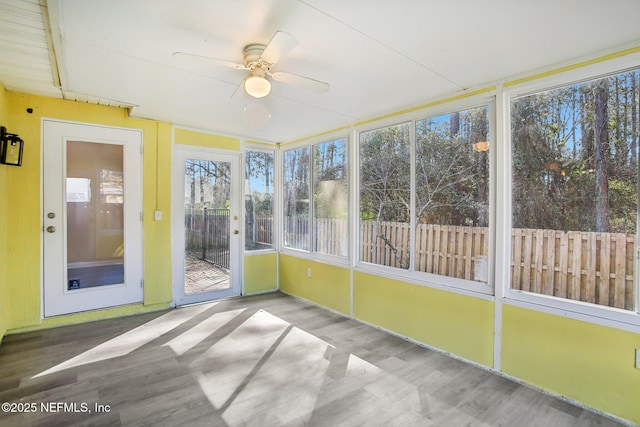 unfurnished sunroom with ceiling fan