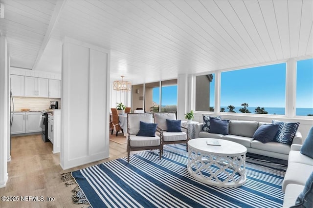 sunroom / solarium featuring wooden ceiling and a water view