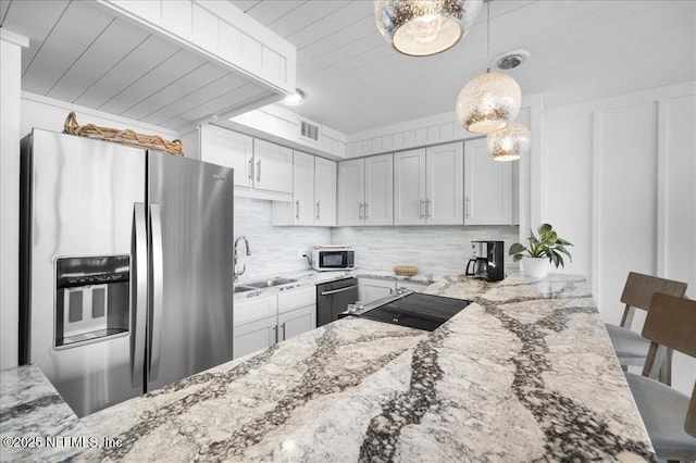 kitchen featuring light stone countertops, appliances with stainless steel finishes, a kitchen bar, and sink