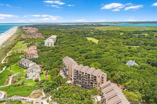 birds eye view of property with a water view and a beach view