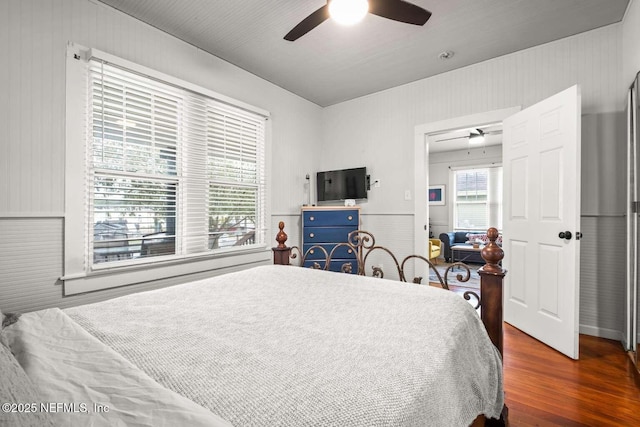 bedroom with multiple windows, dark hardwood / wood-style flooring, and ceiling fan