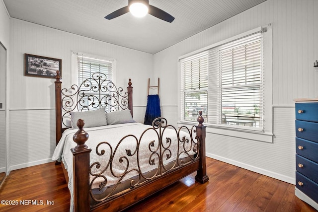 bedroom featuring hardwood / wood-style floors, ceiling fan, and multiple windows