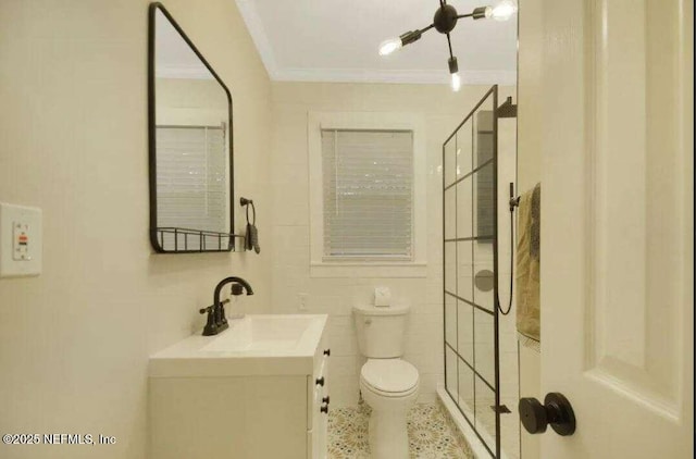 bathroom featuring vanity, toilet, ornamental molding, and tile walls