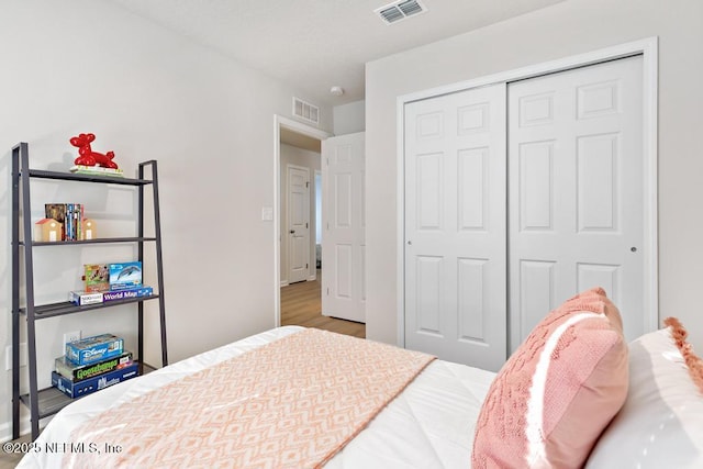 bedroom with wood-type flooring and a closet