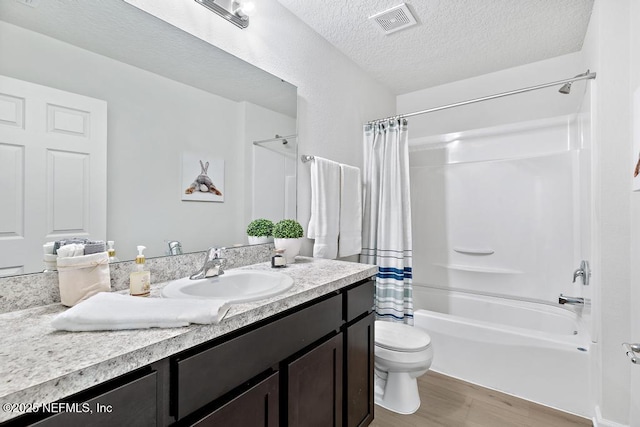 full bathroom featuring hardwood / wood-style floors, vanity, toilet, shower / bath combo with shower curtain, and a textured ceiling