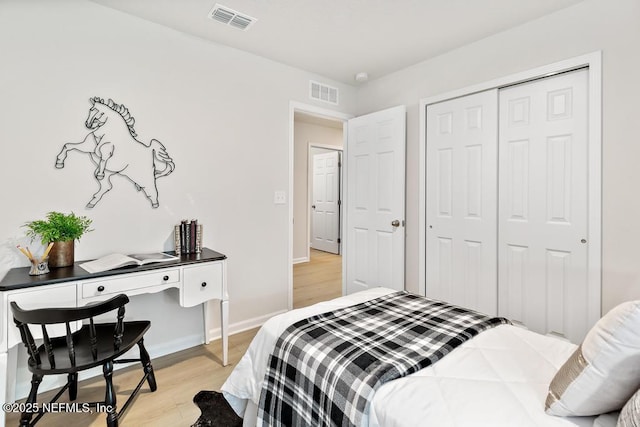 bedroom with light hardwood / wood-style floors and a closet