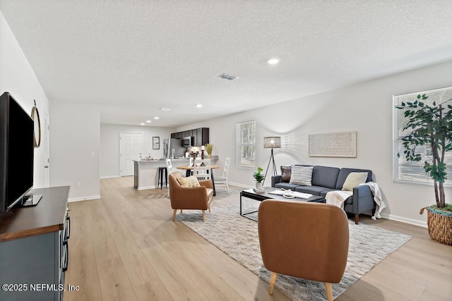 living room featuring light hardwood / wood-style floors and a textured ceiling