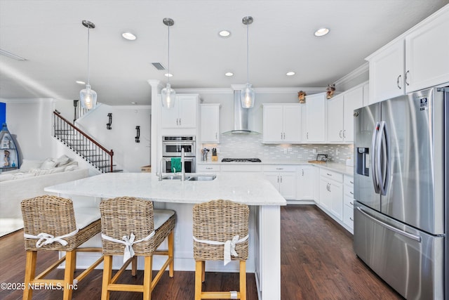 kitchen with wall chimney exhaust hood, white cabinetry, and stainless steel appliances