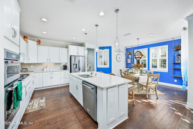 kitchen featuring white cabinets, sink, stainless steel appliances, and an island with sink