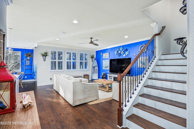 living room featuring a textured ceiling, ceiling fan, crown molding, and dark wood-type flooring