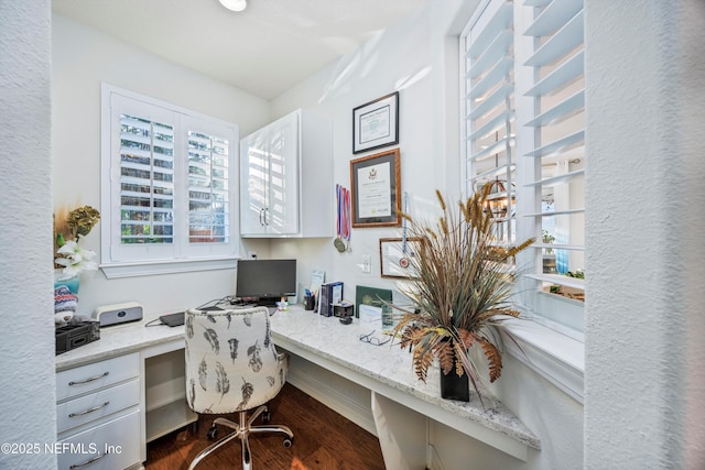 office space featuring dark wood-type flooring and built in desk