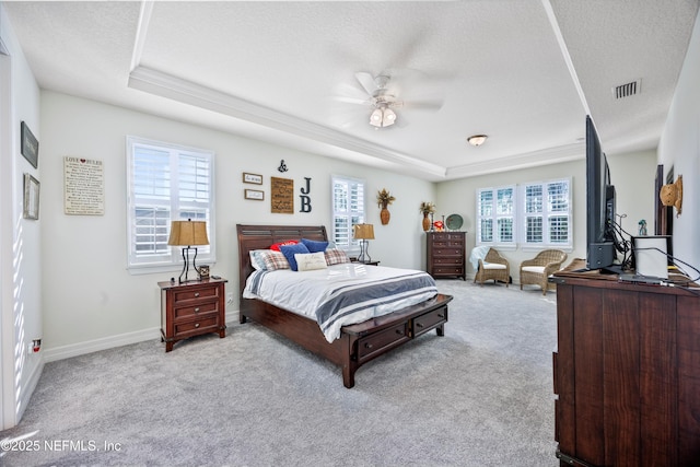 carpeted bedroom with ceiling fan, a raised ceiling, and a textured ceiling