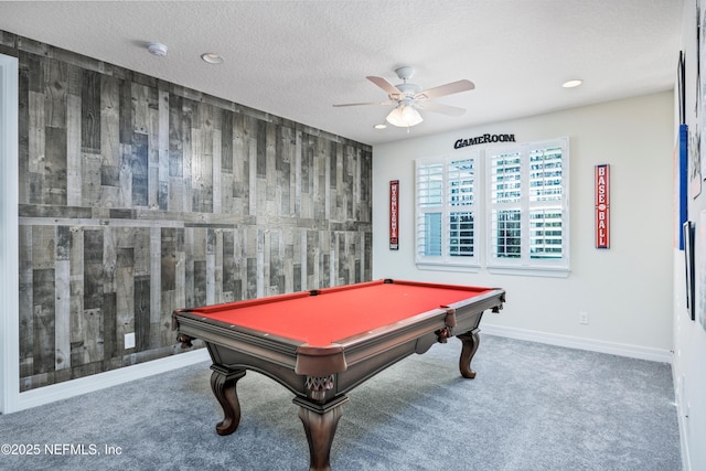 rec room featuring carpet flooring, a textured ceiling, ceiling fan, wood walls, and pool table