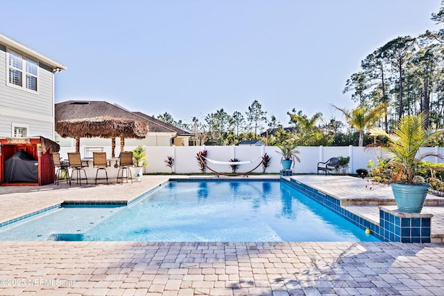 view of pool featuring exterior bar and a patio