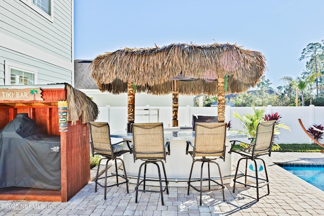 view of patio / terrace featuring a bar and a fenced in pool