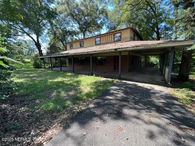 country-style home featuring a carport and a front lawn