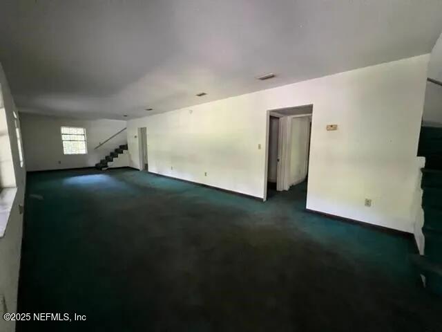 unfurnished room featuring dark carpet