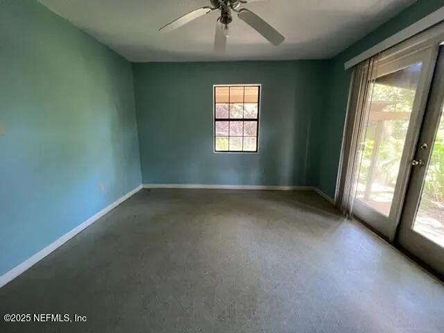 unfurnished room with ceiling fan, french doors, and concrete flooring