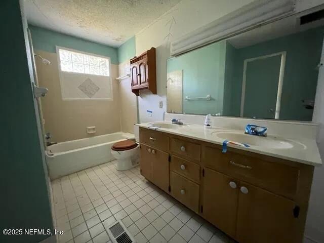 full bathroom with vanity, bathtub / shower combination, tile patterned floors, toilet, and a textured ceiling