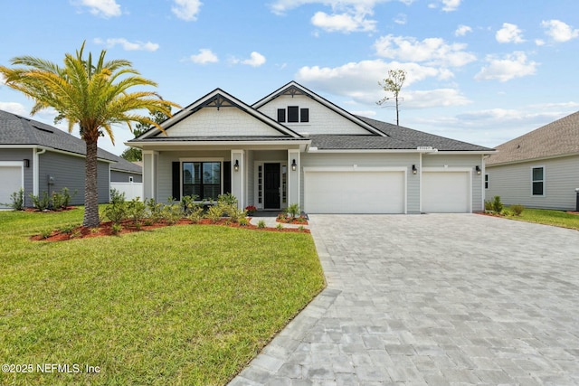 view of front of property featuring a front yard, a porch, and a garage