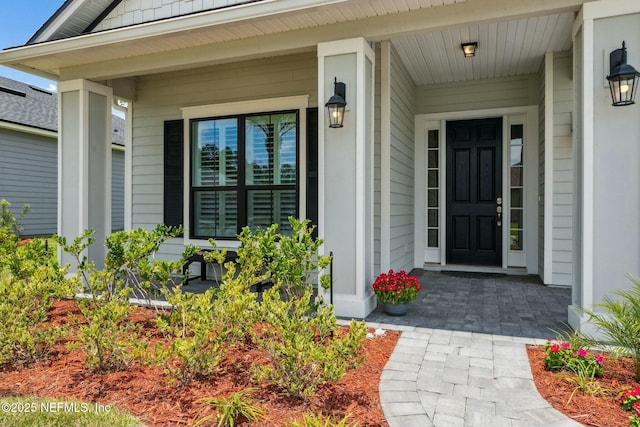 view of exterior entry featuring covered porch