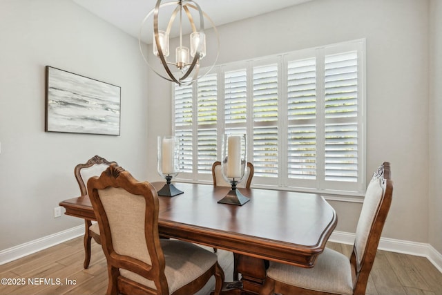 dining area featuring hardwood / wood-style flooring, a healthy amount of sunlight, and an inviting chandelier