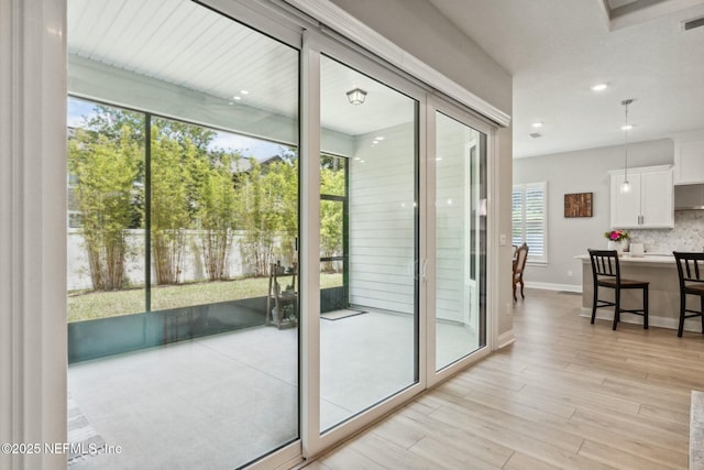 doorway to outside featuring a wealth of natural light and light hardwood / wood-style flooring