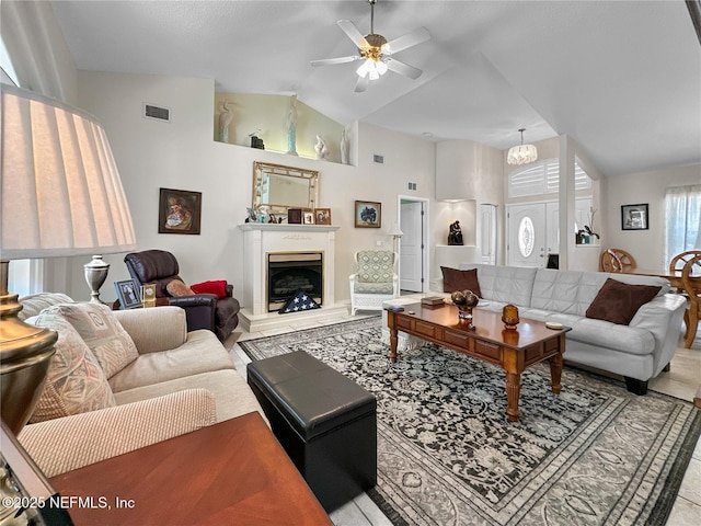 living room featuring tile patterned floors, ceiling fan with notable chandelier, and high vaulted ceiling