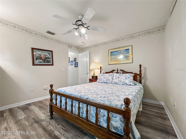 bedroom with a textured ceiling, ceiling fan, and dark wood-type flooring