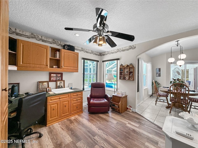 home office featuring ceiling fan, hardwood / wood-style floors, and a textured ceiling