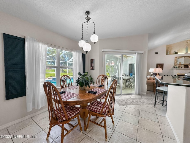 dining area with light tile patterned flooring, a textured ceiling, and vaulted ceiling