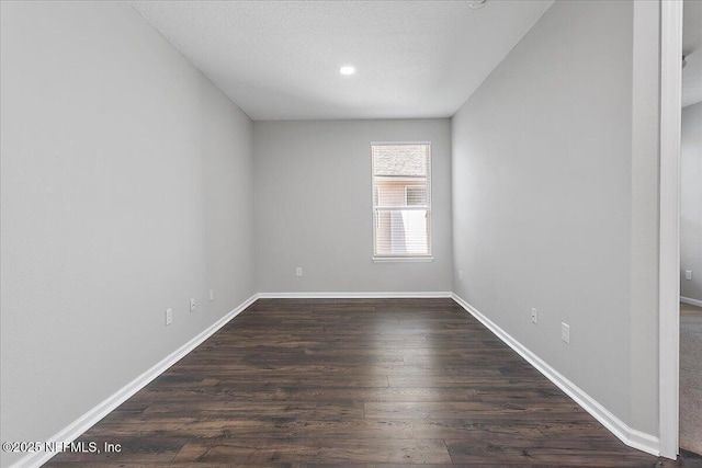 unfurnished room featuring dark wood-type flooring