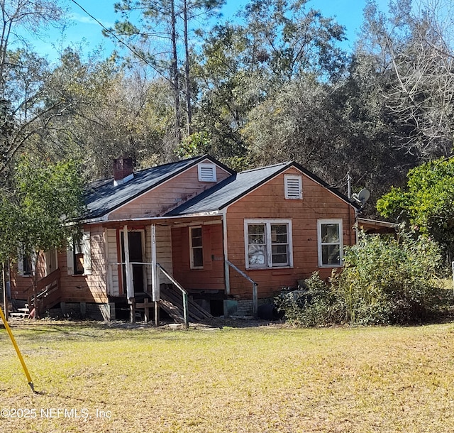 rear view of house with a yard