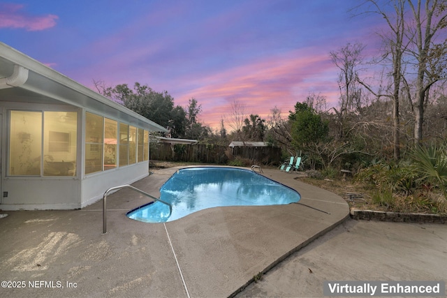 pool at dusk with a patio area