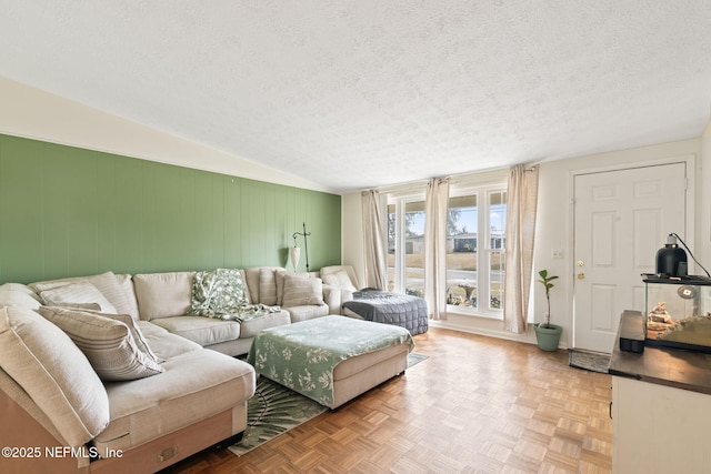 living room featuring a textured ceiling, vaulted ceiling, and light parquet floors