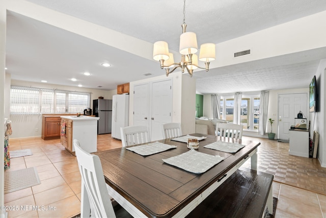 tiled dining room featuring a notable chandelier