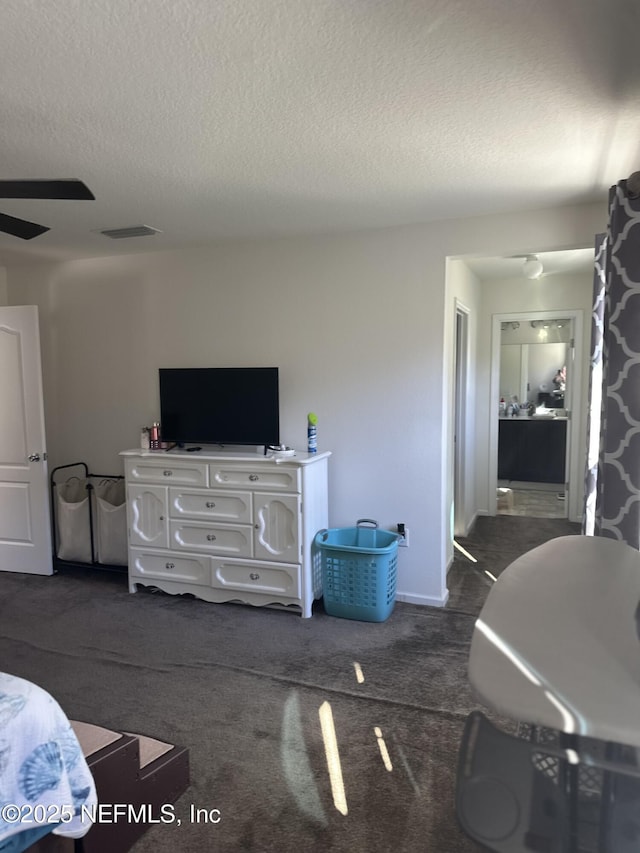 living room with ceiling fan, dark carpet, and a textured ceiling