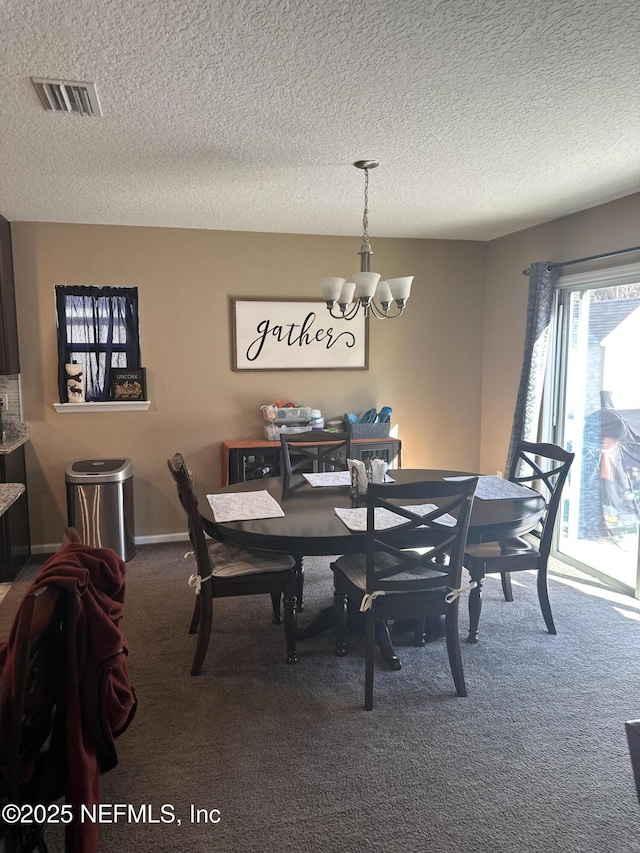 dining space with carpet flooring, a textured ceiling, and a notable chandelier