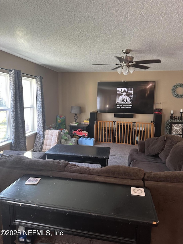 living room with ceiling fan and a textured ceiling