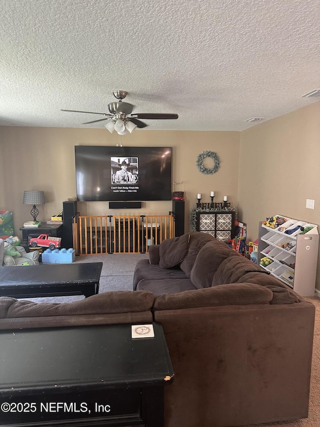 carpeted living room with ceiling fan and a textured ceiling