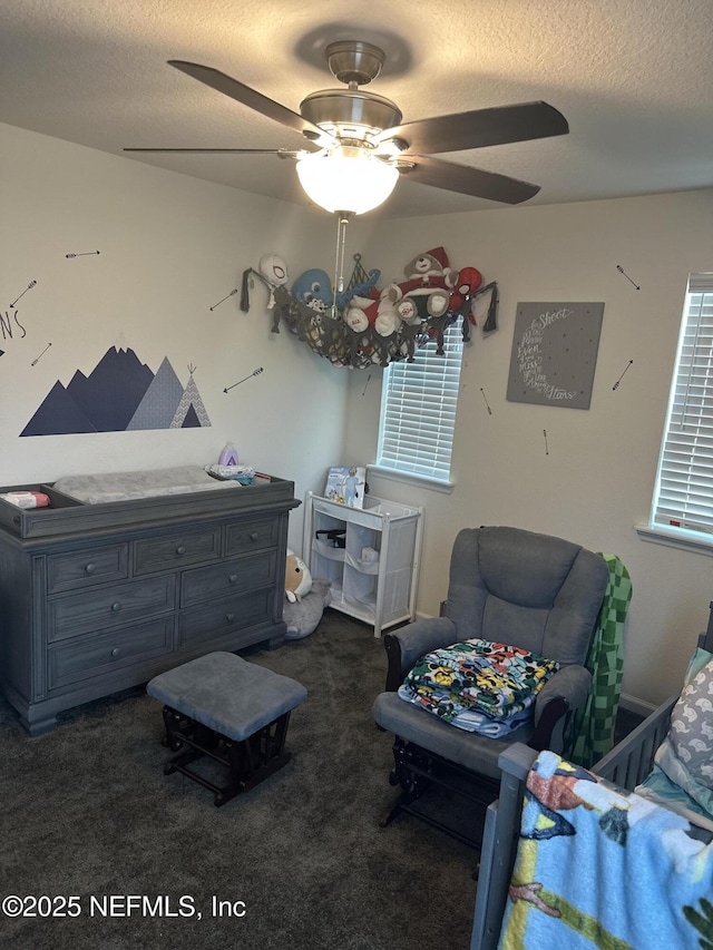 bedroom featuring a textured ceiling, dark carpet, and ceiling fan