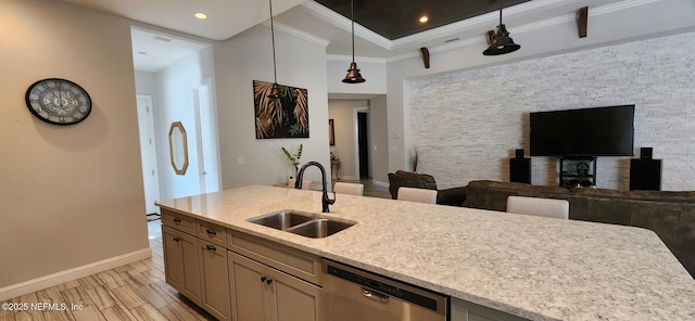 kitchen with pendant lighting, dishwasher, sink, ornamental molding, and light stone counters