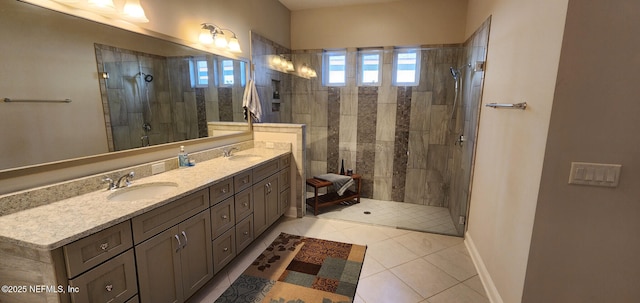 bathroom with tile patterned flooring, vanity, and tiled shower