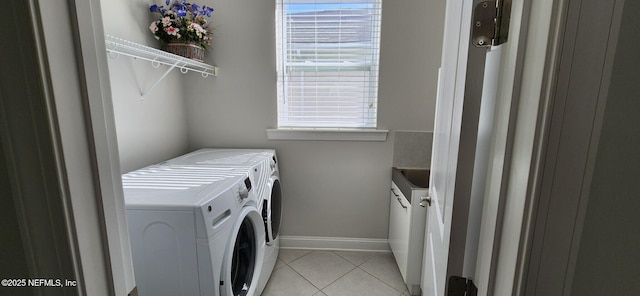 laundry area with cabinets, light tile patterned floors, and washing machine and dryer