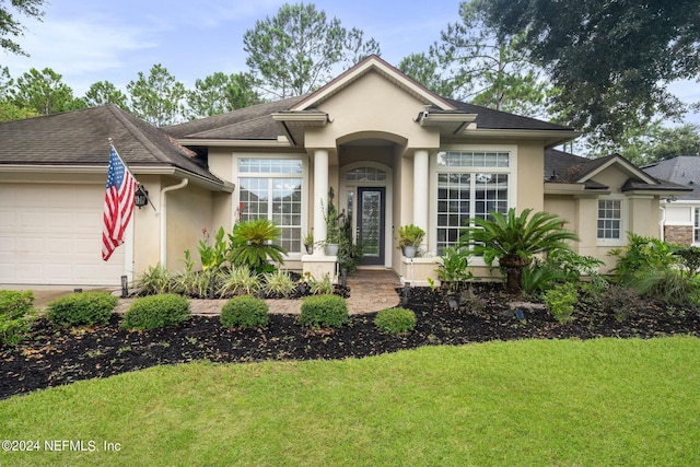 view of front of property with a front yard and a garage