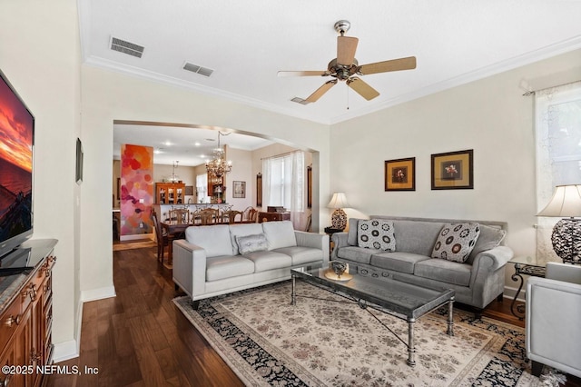 living room with ceiling fan with notable chandelier, dark hardwood / wood-style flooring, and crown molding