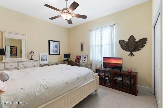 carpeted bedroom with ceiling fan and a closet