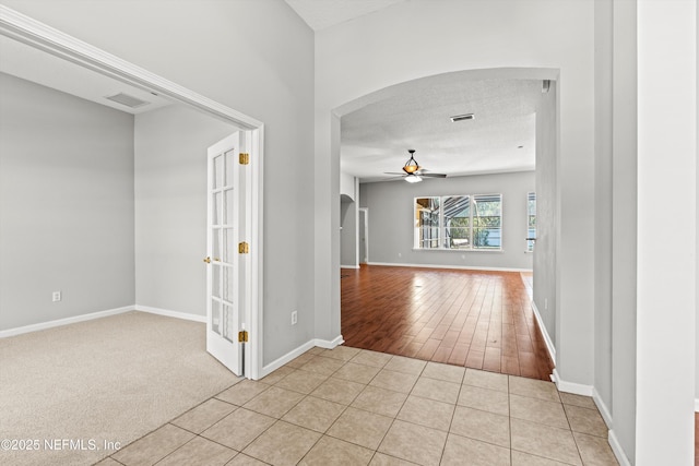 hall with light tile patterned floors and a textured ceiling